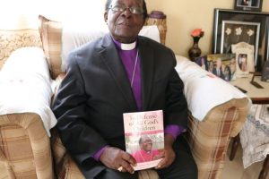 BISHOP SENYONJO WITH A COPY OF HIS BIOGRAPHY